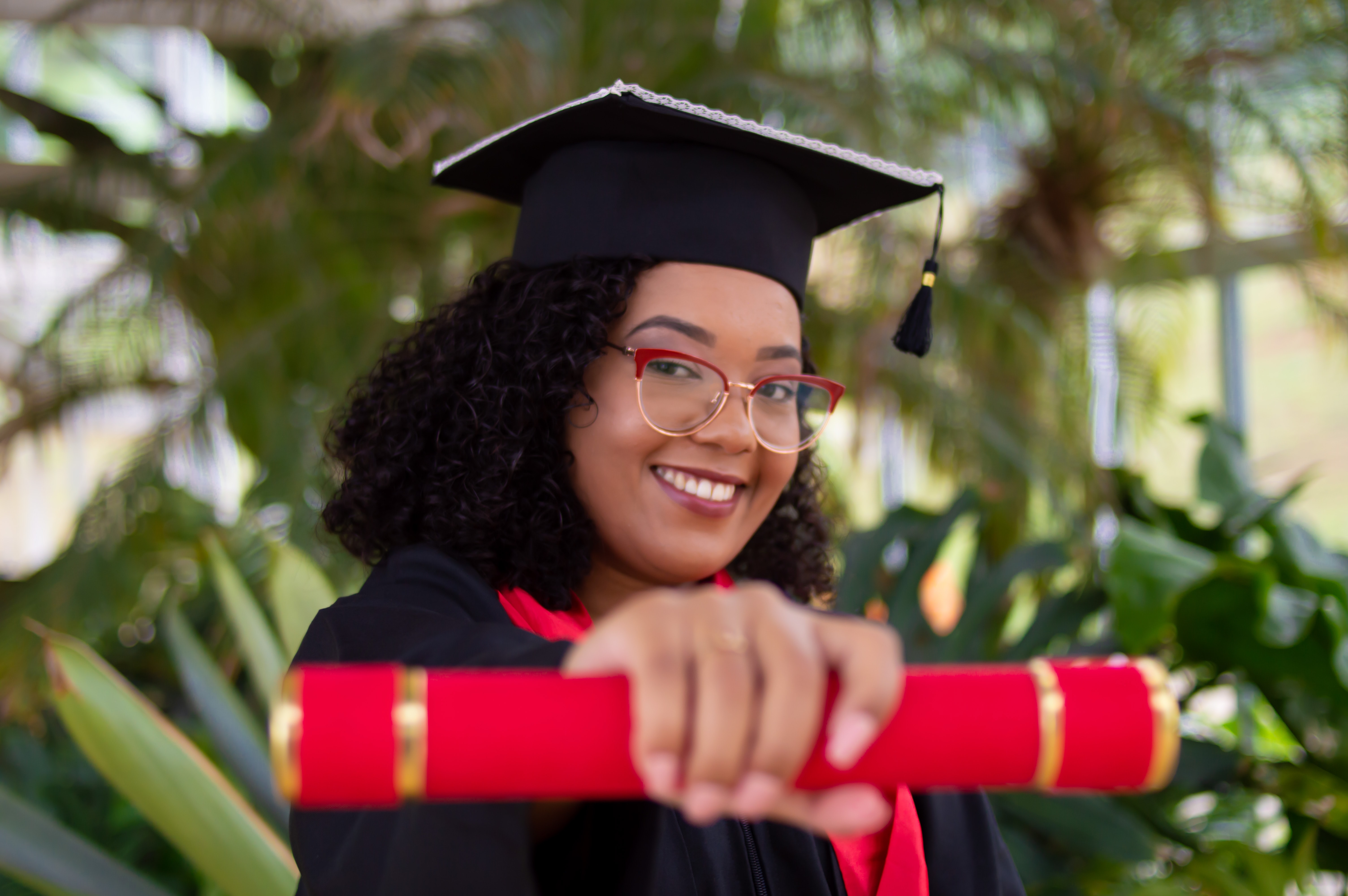 Female graduate holding diploma scroll.